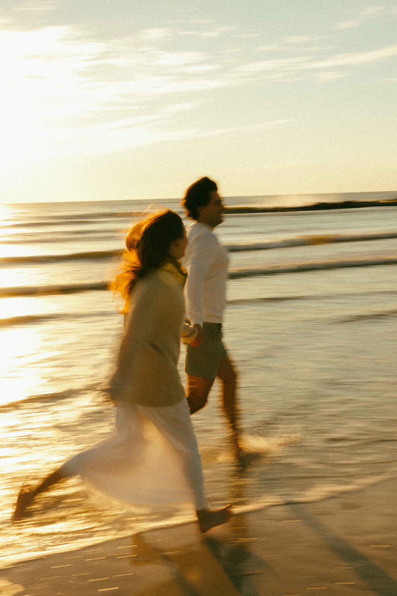 Couple running on Honeymoon Island , Florida. Documentary style couples session photos.