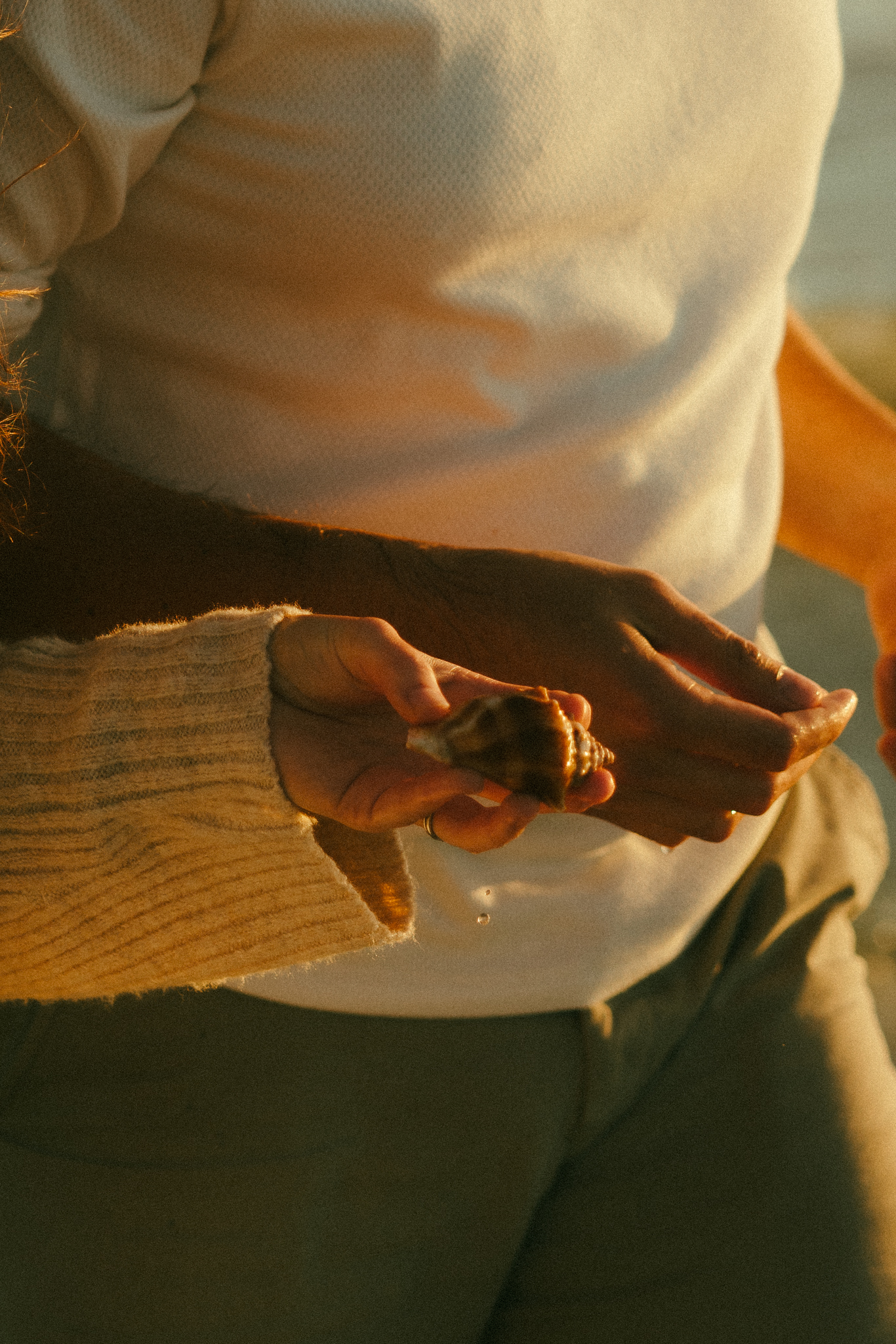 Documentary style photo of hand holding dripping seashell.