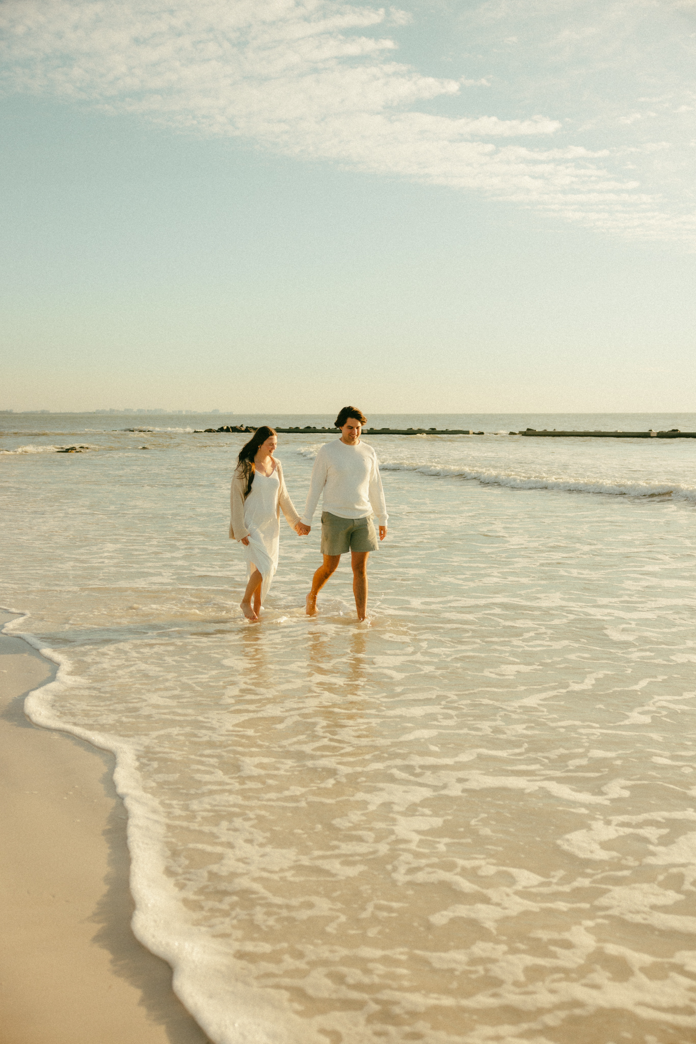 Couple walking in the waves at Honeymoon Island State Park Beach couples photo session.