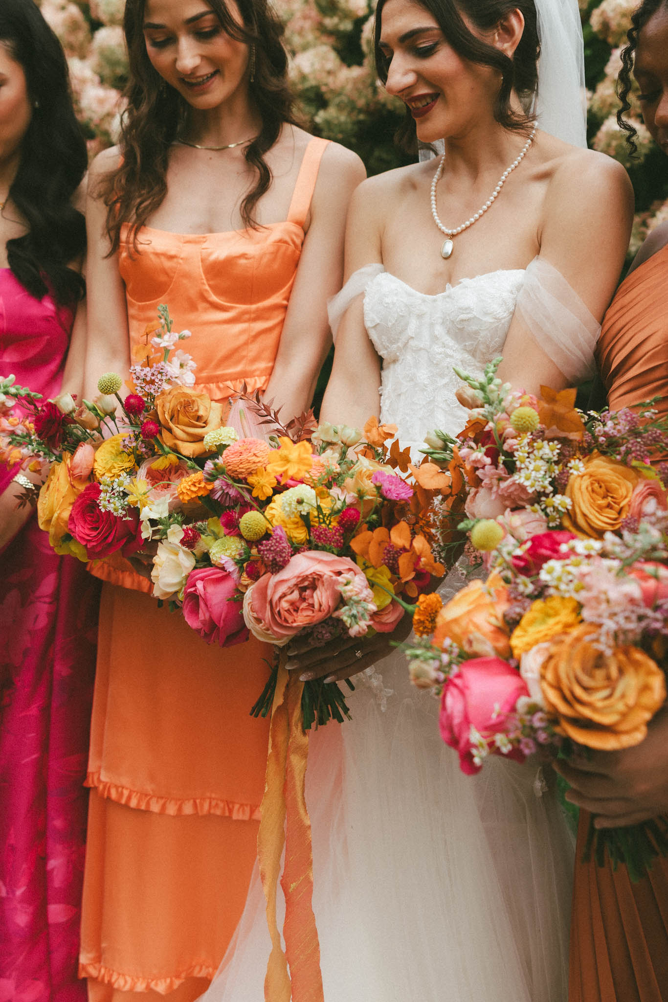 Bride with bridesmaids with hot pink, yellow, and orange flowers