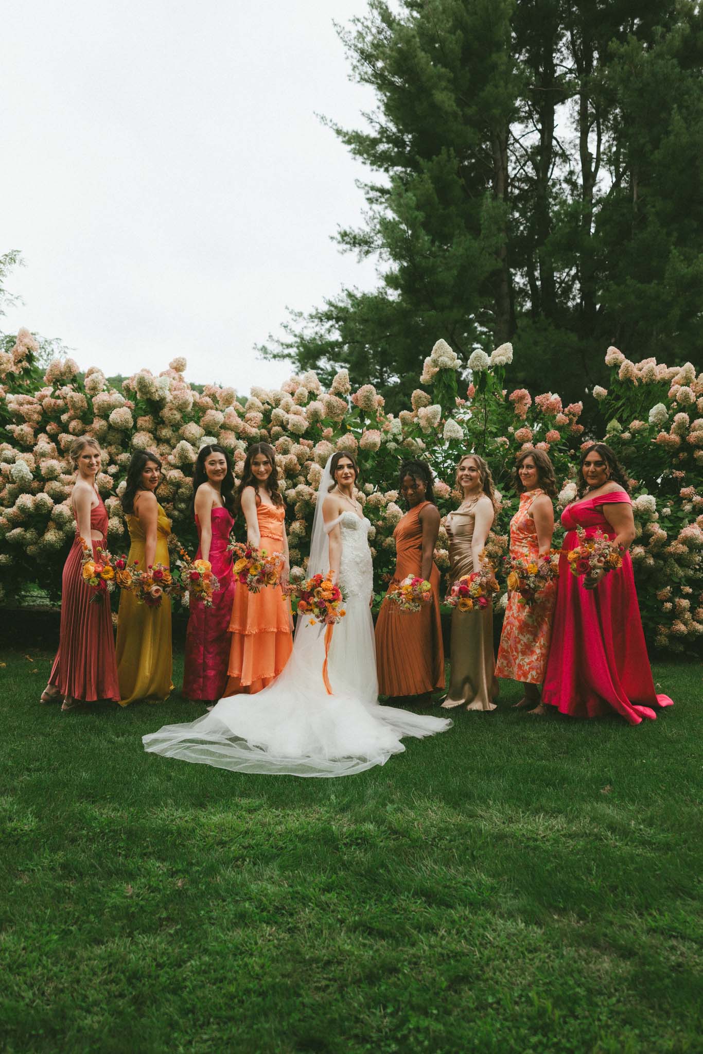 Bride with bridesmaids with hot pink, yellow, and orange flowers