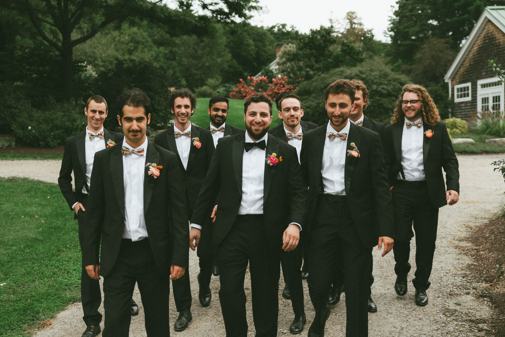 groom and groomsmen walking at the gardens at Uncanoonuc