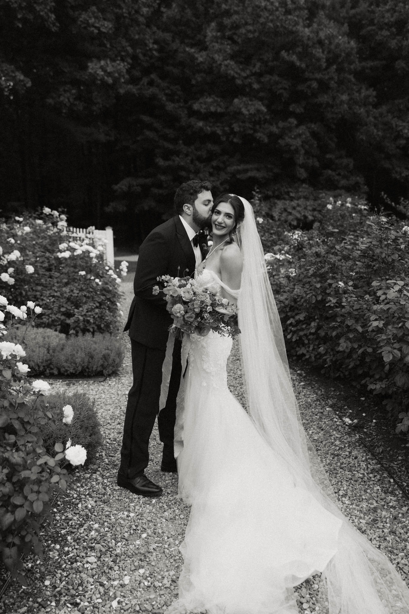 Black and white bride and groom in rose garden