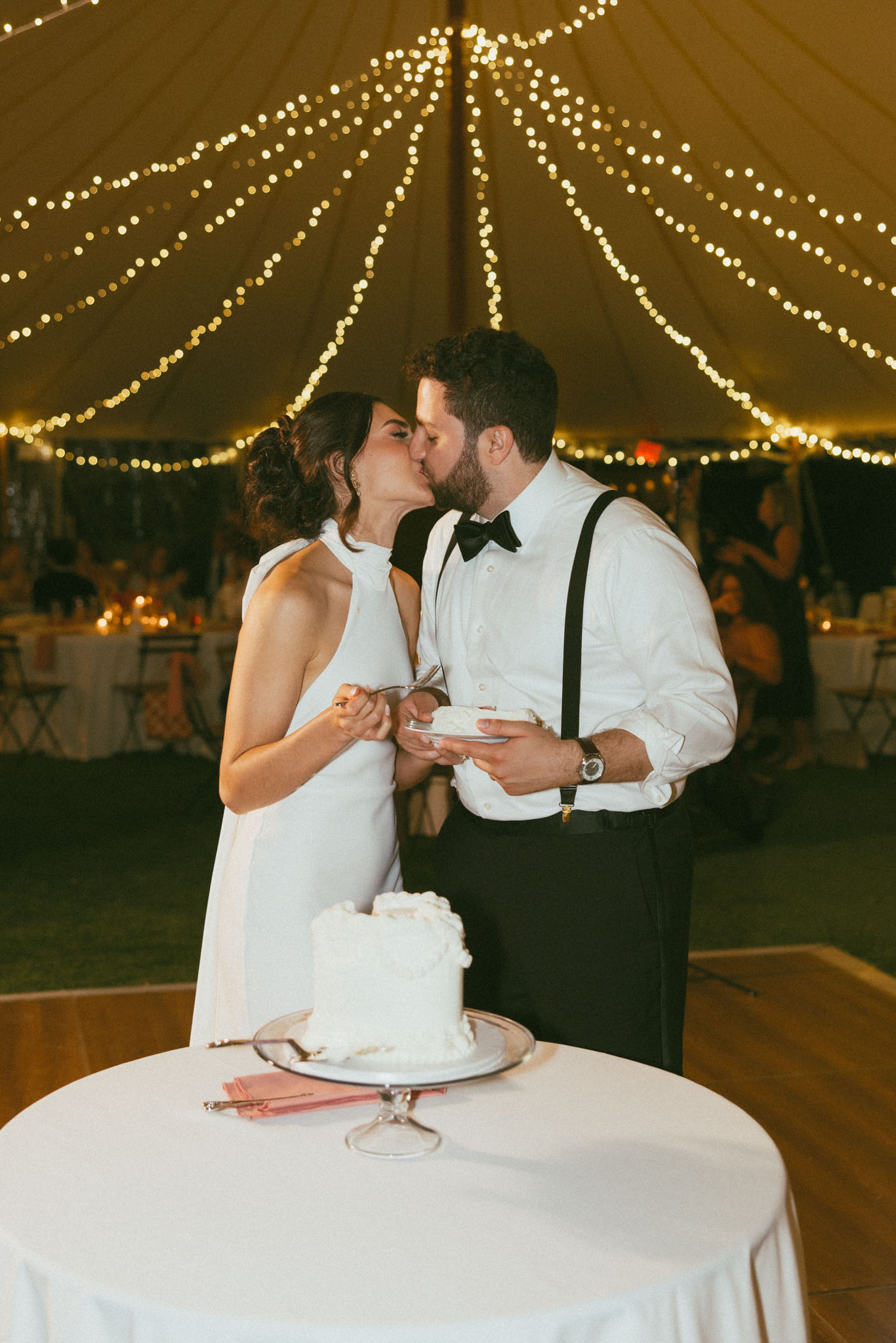 Bride and groom cutting cake and kissing