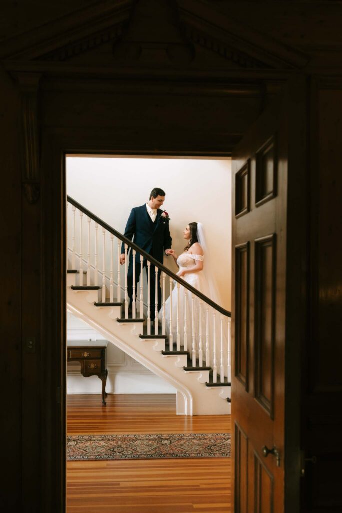 Bride and groom on staircase at the John Hay Estate at The Fells wedding venue